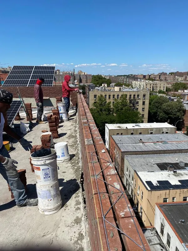 Rooftop restoration work with New York City skyline view from Queens